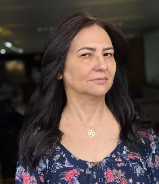 Cliente com cabelo escuro escovado no studio SoHo, com o salão ao fundo